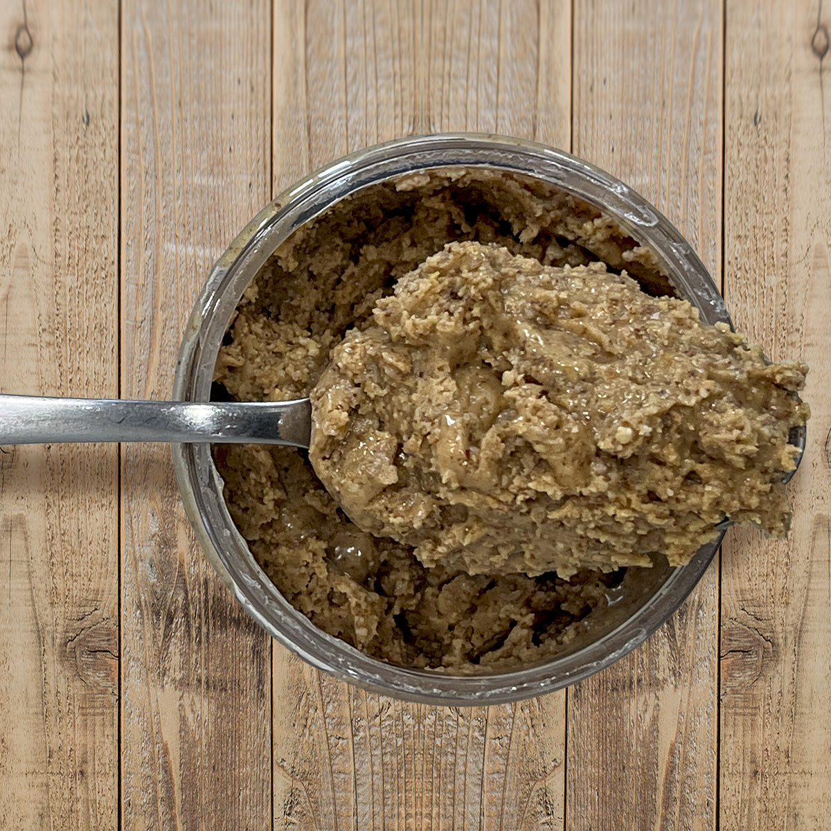 Cinnamon Almond Butter top view of open container with spoon full of peanut butter