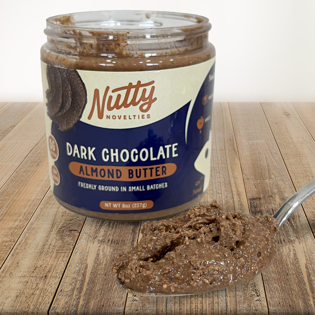 Dark Chocolate Almond Butter with spoon full of peanut butter in front of container