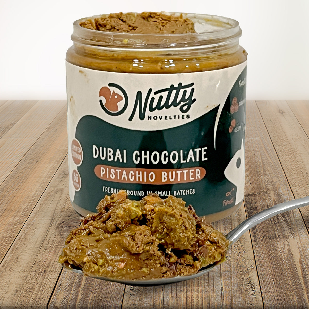 Dubai Chocolate Pistachio Butter with spoon full of peanut butter in front of container
